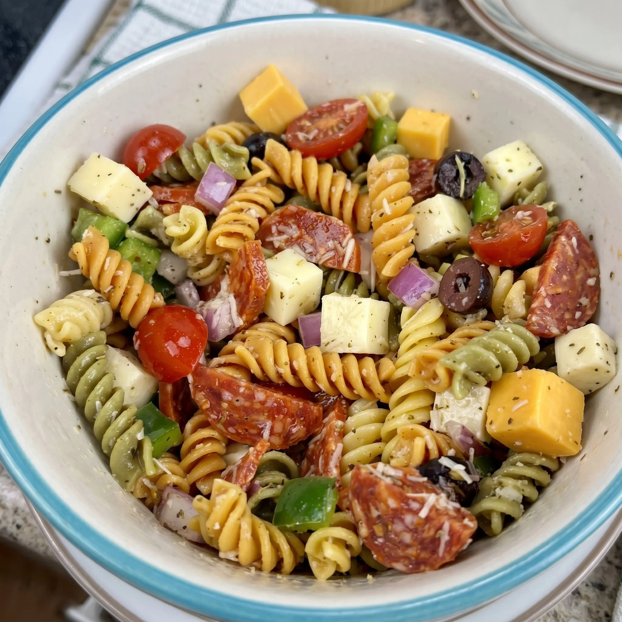 Bowl of classic pasta salad with vegetables and dressing