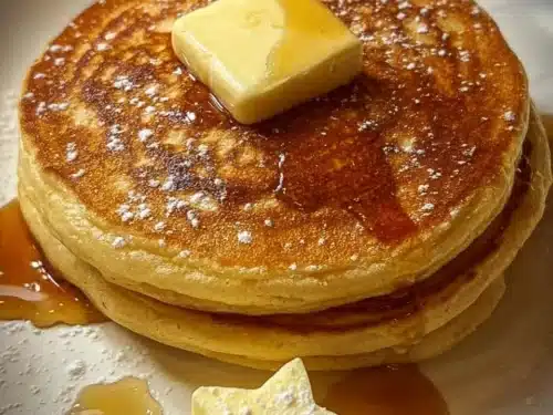 Delicious pancakes topped with melting butter, served on a plate